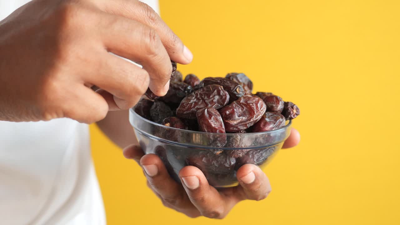 Person holding a bowl of dates