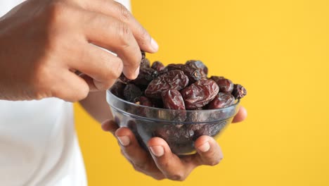 person holding a bowl of dates