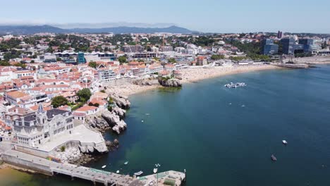 Toma-Aérea-En-órbita-De-La-Playa-Rainha-Y-Toda-La-Zona-De-La-Bahía-De-Cascais,-Portugal