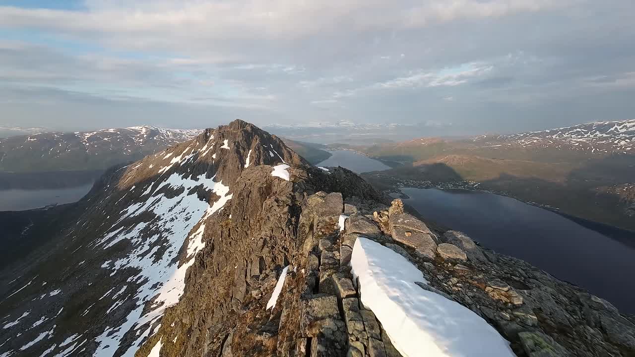 FPV close proximity flying along a mountain ridge during golden hour near Troms&oslash; in northern Norway