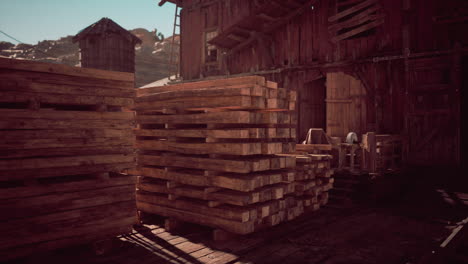 wooden pallets stacked in an old barn during daytime in a rural setting