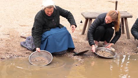 two women panning for gold in water