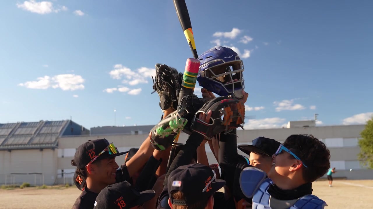 Squadra giovanile di baseball che celebra la vittoria sul campo.