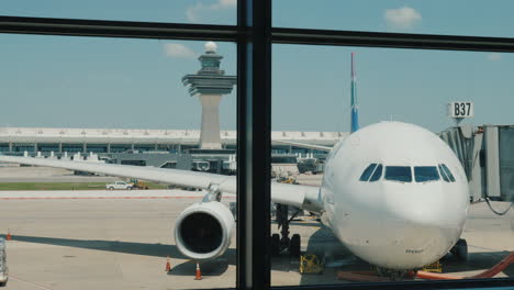 avión de pasajeros fuera de la ventana de la terminal del aeropuerto