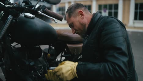 hombre reparando una motocicleta personalizada en la calle