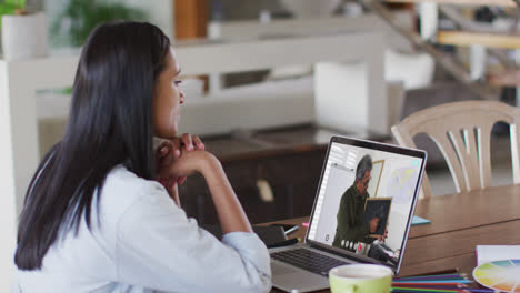 Caucasian-female-student-using-laptop-on-video-call-with-male-teacher