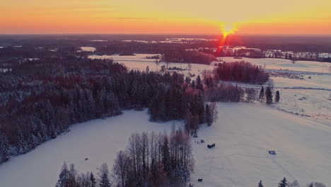 gente jugando en la nieve fuera de la cabaña de madera en letonia al atardecer