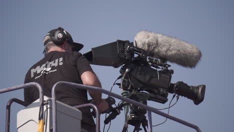 cameraman operating a professional camera on a platform