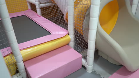 Leeres-Kleinkind-Spielzimmer-Für-Kinder,-Inneneinrichtung-Mit-Trampolin-Und-Kleinem-Rutschrohr-Und-Sicherheitsnetz
