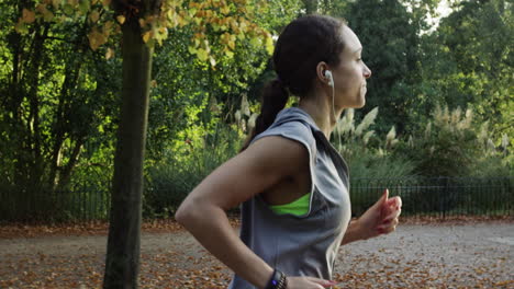 Runner-woman-running-in-park-exercising-outdoors-fitness-tracker-wearable-technology