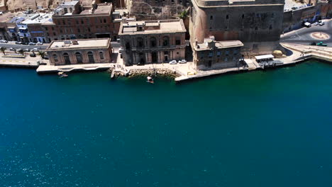 Toma-Aérea-Panorámica-Desde-El-Mar-Azul-Celeste-Hasta-Los-Hermosos-Jardines-De-Barrakka-En-Un-Día-Soleado,-Valetta,-Malta