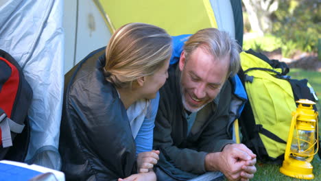 happy hiker couple interacting while looking at each other in tent