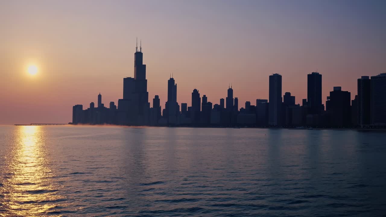 Captivating sunset illuminates city skyline, with reflections shimmering on water, creating a serene ambiance and showcasing the beauty of urban architecture in motion