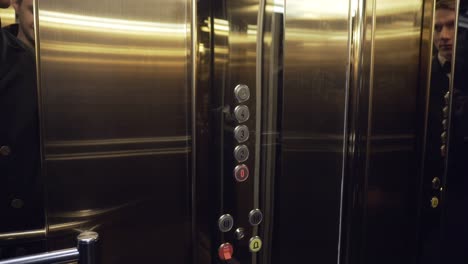 male hand pushing the elevator button labeled with the number one. front shot.