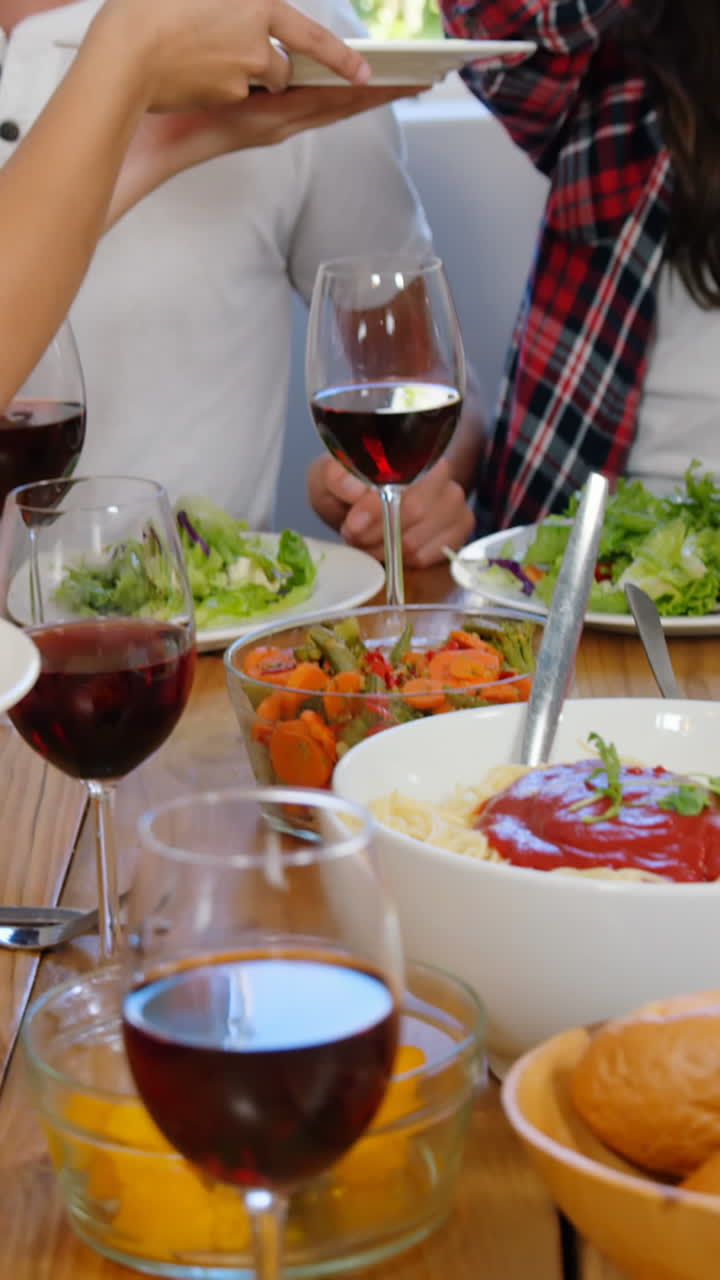 Amici felici che fanno un pranzo salutare con vino.