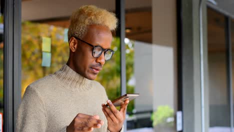 Vorderansicht-Eines-Jungen-Schwarzen-Geschäftsmannes,-Der-In-Einem-Modernen-Büro-4k-Mit-Dem-Mobiltelefon-Spricht