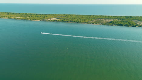 Navegación-En-Lancha-Motora-Por-El-Río-Piedra-Dejando-Estela-En-Aguas-Tranquilas-Durante-El-Día-Cerca-De-El-Rompido,-Huelva,-España