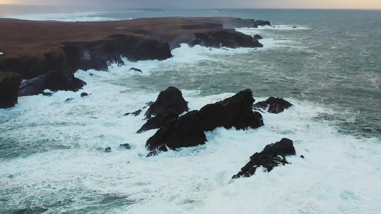 Drone shot of waves crashing over the headland cliffs in Ness on a stormy day