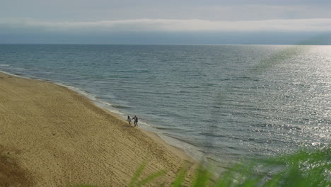 two people running sea shore together. ocean wave on beach landscape aerial view