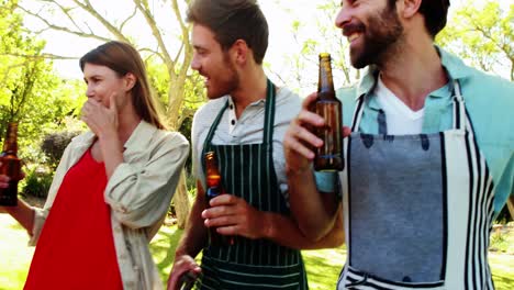 grupo de amigos brindando una botella de cerveza en el parque