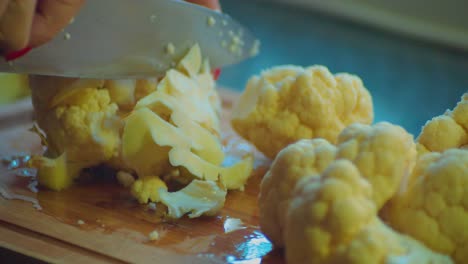 Cutting-With-Knife-Raw-White-Cauliflower-on-Kitchen-Table,-Close-Up-Full-Frame