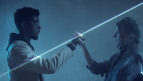 Multiethnic-Couple-Holding-Hands-in-Dark-Room-with-Laser-Light-Sheet