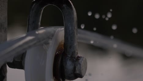 close up blurry mechanism of a rotating spinning wheel with slow motion water drops falling