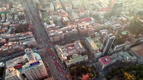 Luftwagen-In-Der-Nationalbibliothek-Und-Dem-Nationalarchiv-Von-Chile,-Verkehr-In-Der-Avenue-Und-In-Der-Innenstadt-Von-Santiago-Gebäuden-Bei-Sonnenuntergang,-Chile