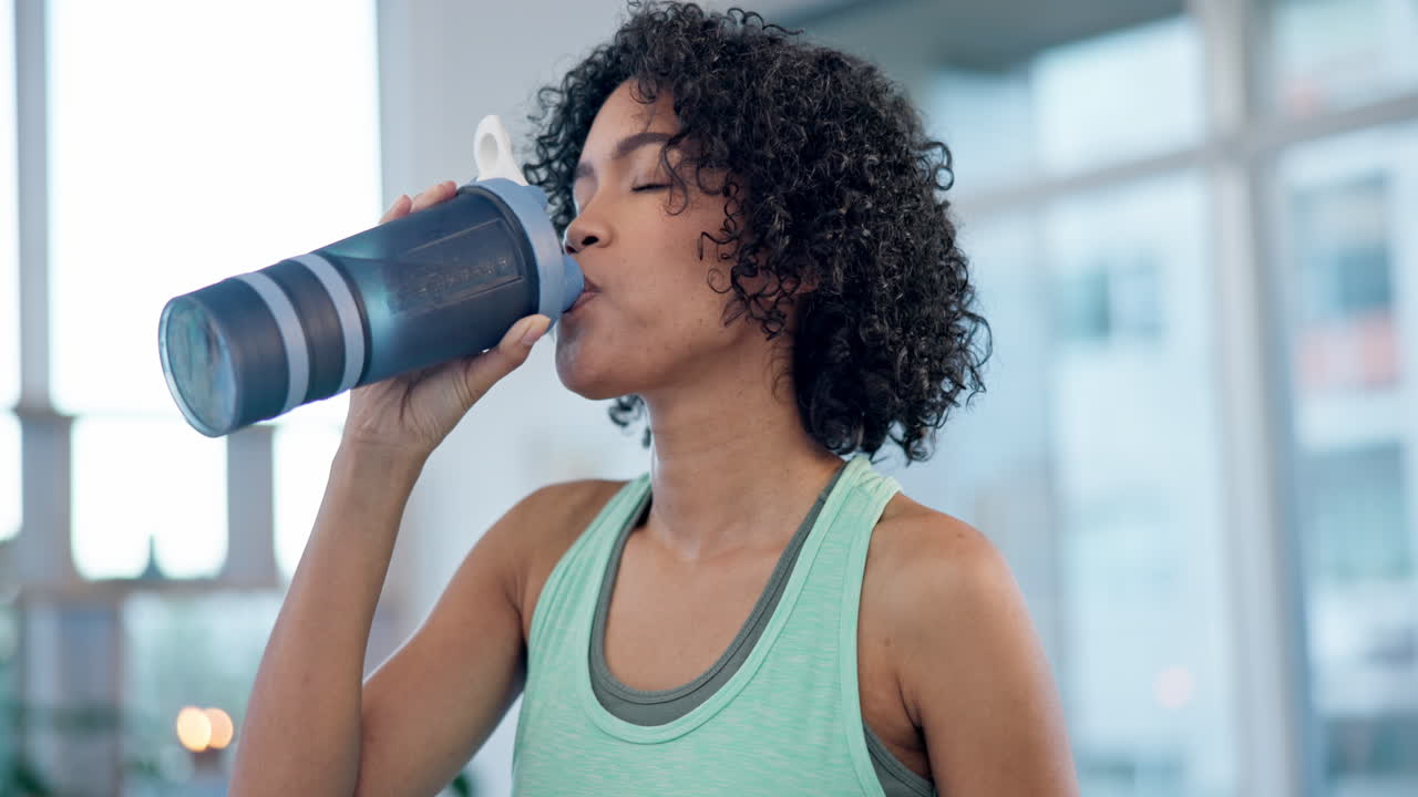 mujer, casa y beber de la botella de agua