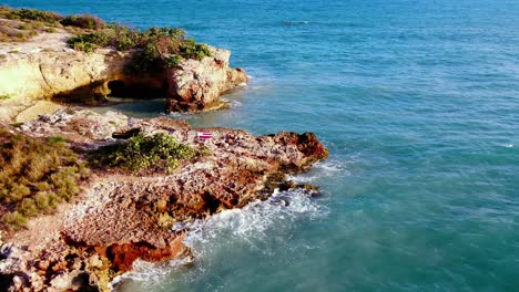 Colorida-Bandera-Puertorriqueña-En-Roca-Junto-Al-Arco-En-Cabo-Rojo-Puerto-Rico