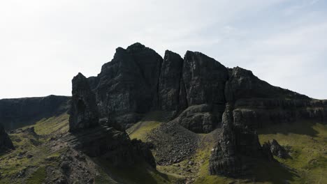 aerial view pulling away from scotland's old man of storr with overcast skies