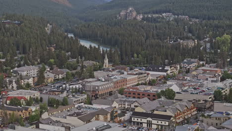 Banff-Ab-Canada-Vista-Aérea-V7-Con-Drones-Sobrevolando-La-Ciudad-Capturando-Un-Paisaje-Urbano-Pintoresco,-Calles-Pintorescas-Bordeadas-De-Tiendas-Y-Restaurantes-Rodeados-De-Frondosos-Bosques---Filmado-Con-Mavic-3-Pro-Cine---Julio-De-2023