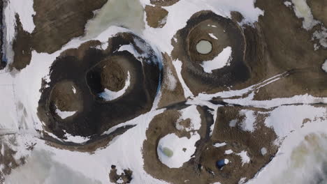 birdseye aerial view of inactive volcano craters in snowy winter landscape of iceland, high angle drone shot