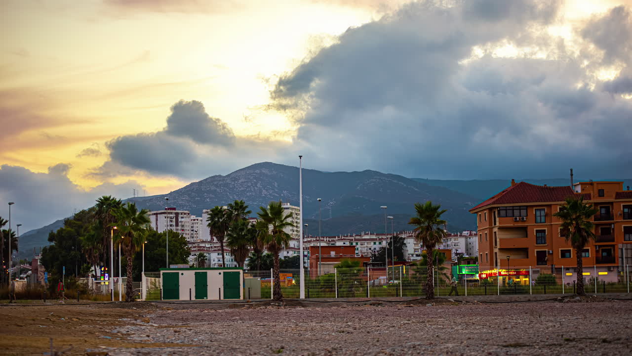 un lapso de tiempo de una vista de puesta de sol con nubes dramáticas en una ciudad cerca de una montaña en españa