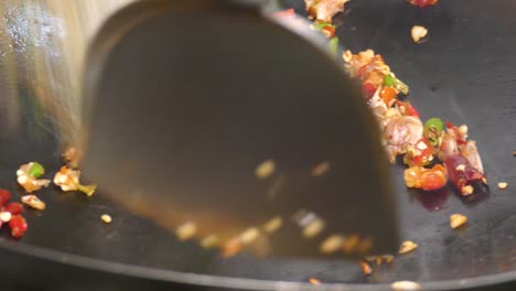 close-up footage of chilli, garlic and spice cooking in the wok