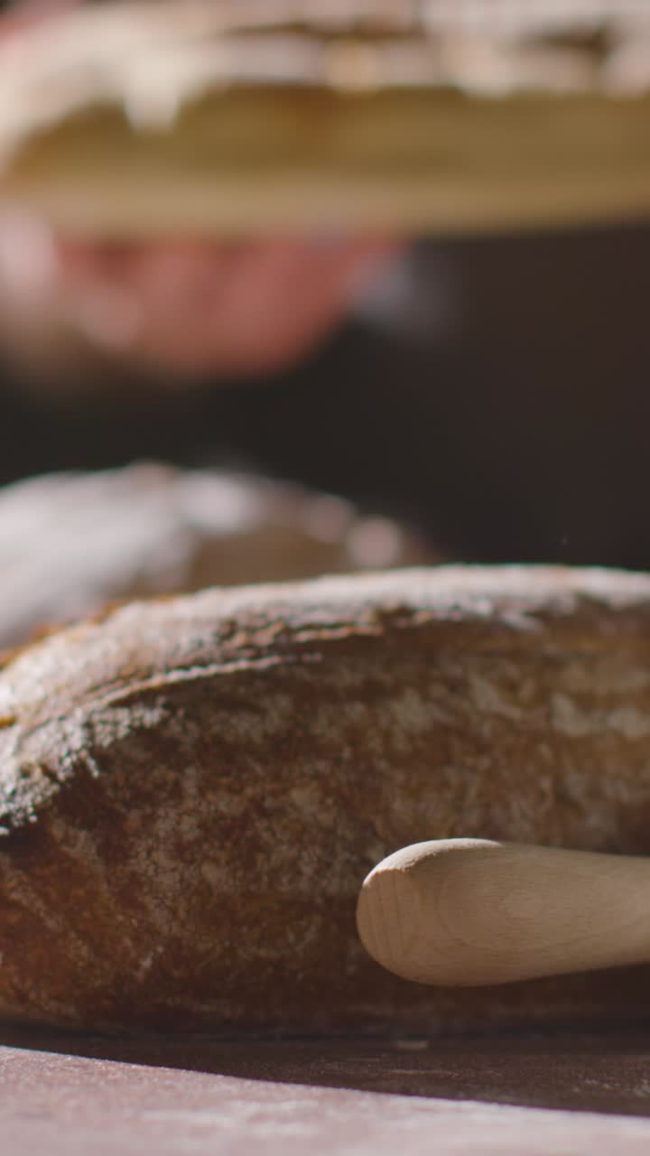 작업 표면에 새로 구운 을 넣는 사람의 수직 낮은 키