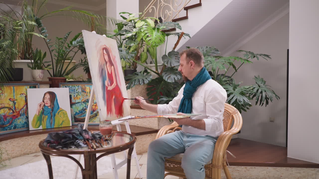 남자가 여성 초상화에 빛과 그림자를 넣습니다. 예술가는 윤을 윤하고 예술적 과정의 숙달을 반영하는 세부적인 수준으로 예술 작품을 주입합니다.