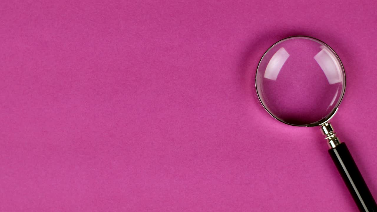 ручное помещение лупы на пурпурном фоне для показа поиска или расследования