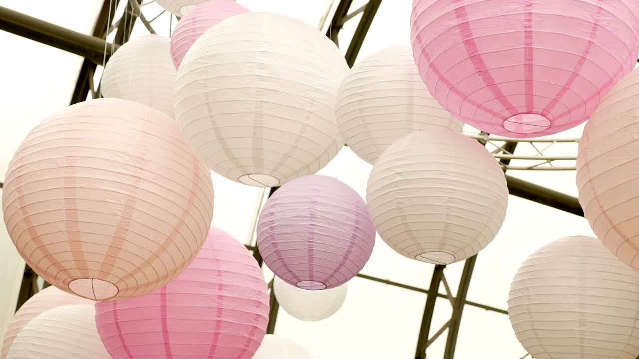 bolas rosadas blancas de papel de arroz colgando de las ramas de los árboles verdes