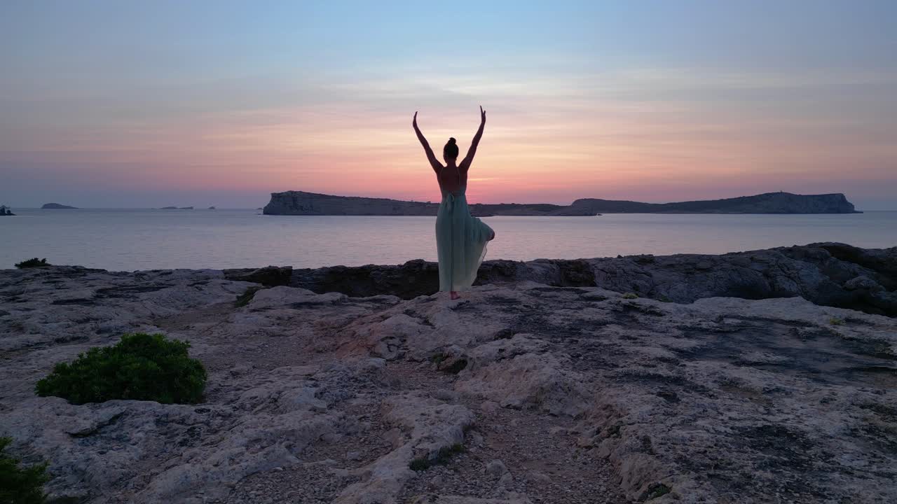Yoga Hippie Girl at sunset with island in the background, Ibiza, Spain. Fabulous aerial view flight speed ramp hyper motion time lapse