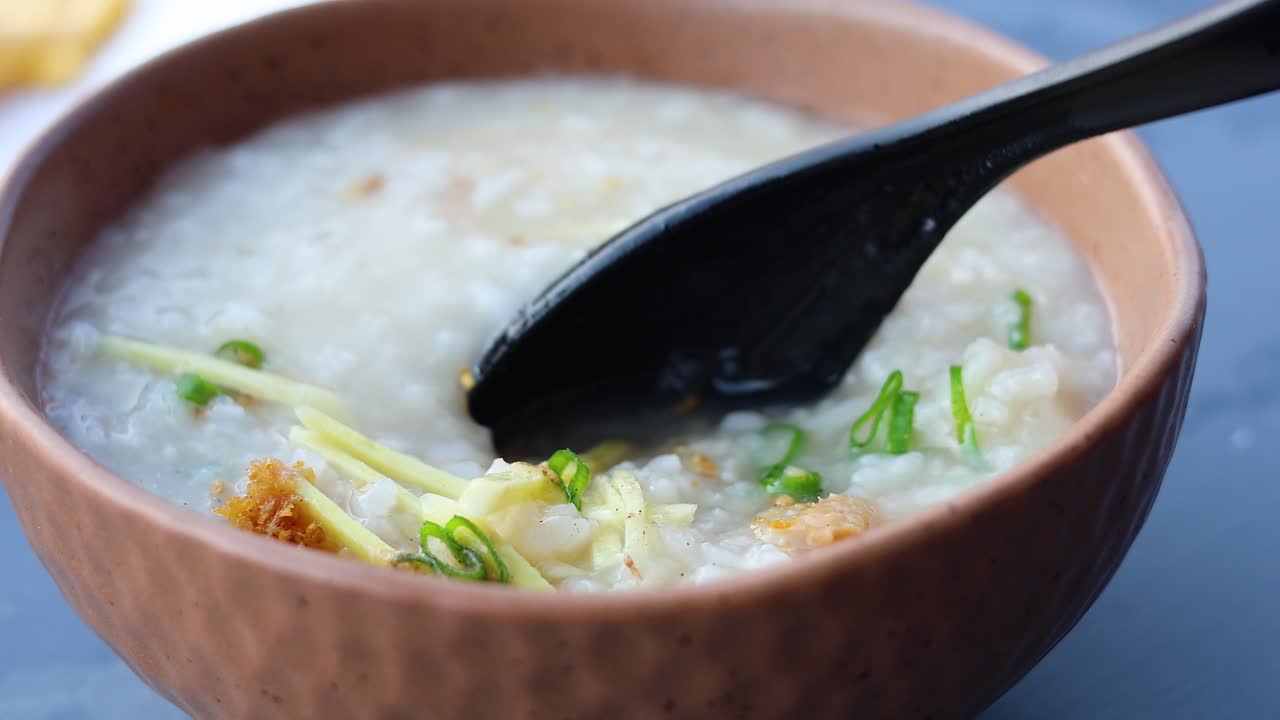 Mengaduk dan menyantap bubur nasi lezat