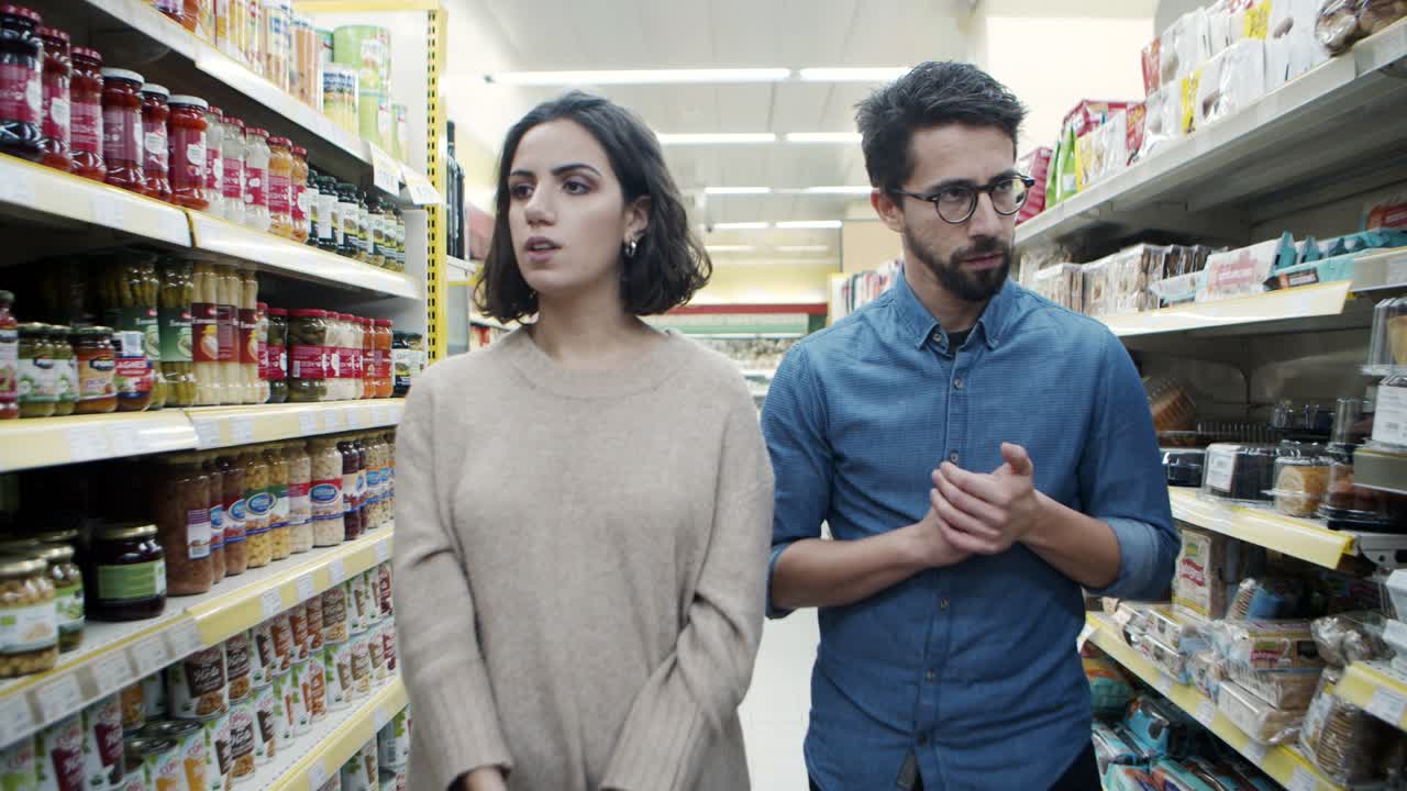 pareja caminando y hablando en la tienda de comestibles