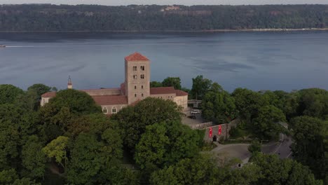 clockwise aerial orbit rising above the cloisters museum in upper manhattan nyc on the bank of the hudson river