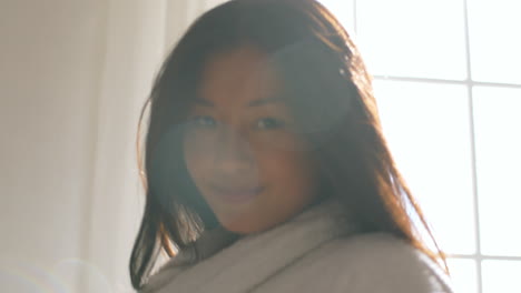 woman stretching in bathrobe by window