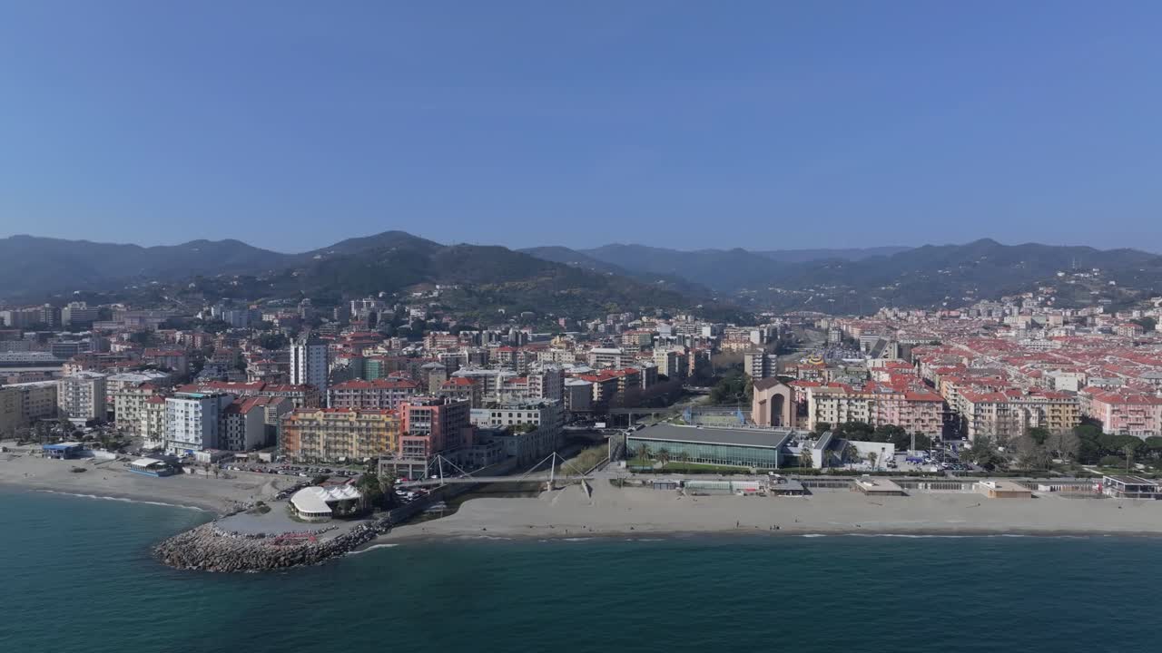 Savona beach aerial shot with city and mountains in the background on a clear day