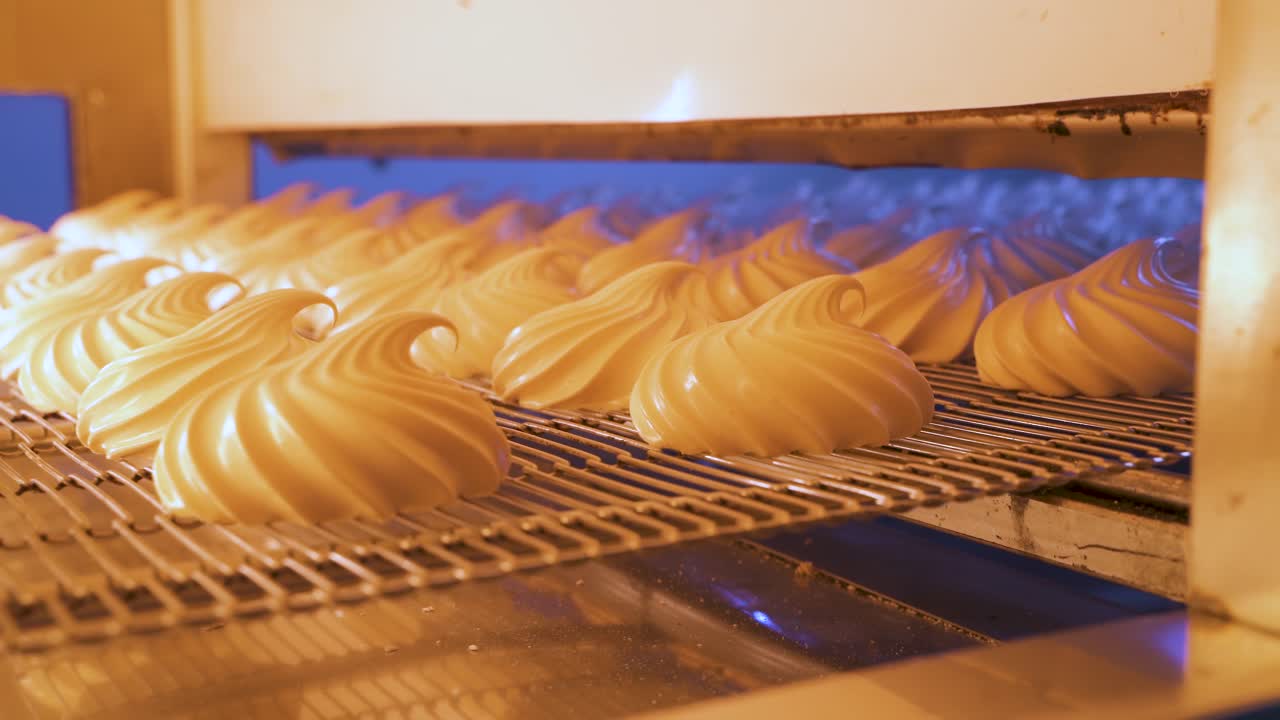 Marshmallow production workshop. Souffle on metal belt moves along the conveyor in the drying apparatus. Confectionery factory of natural products