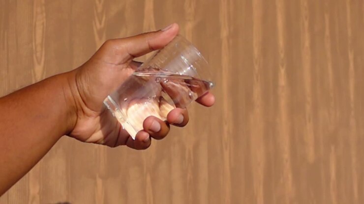 Hand pouring water from a glass
