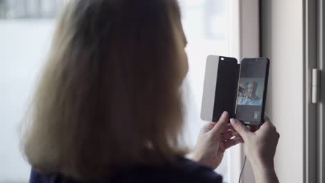 woman holding smartphone, chatting with husband