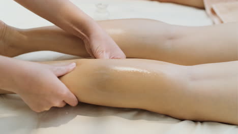 masseuse giving leg massage to woman