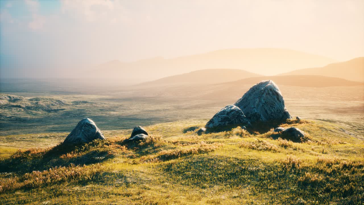 prado con enormes piedras entre la hierba en la ladera de la colina al atardecer